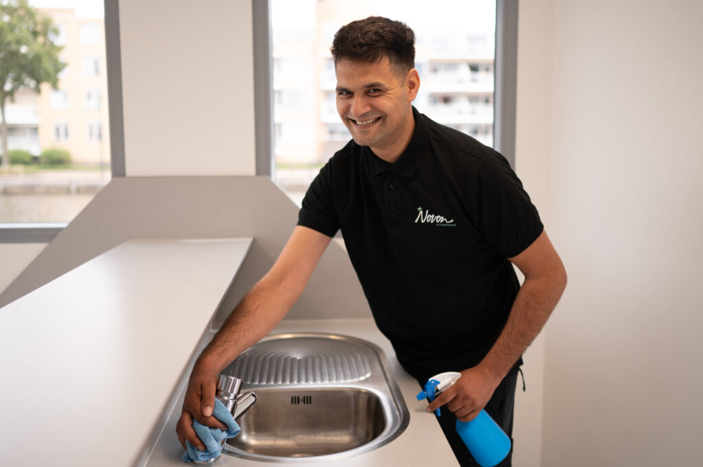 Collega die wasbak schoonmaakt.