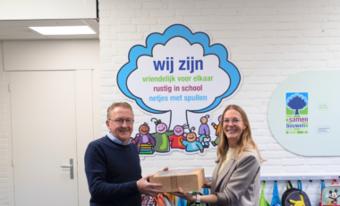 Collega overhandigt taart aan conciërge na aanleiding van een project.