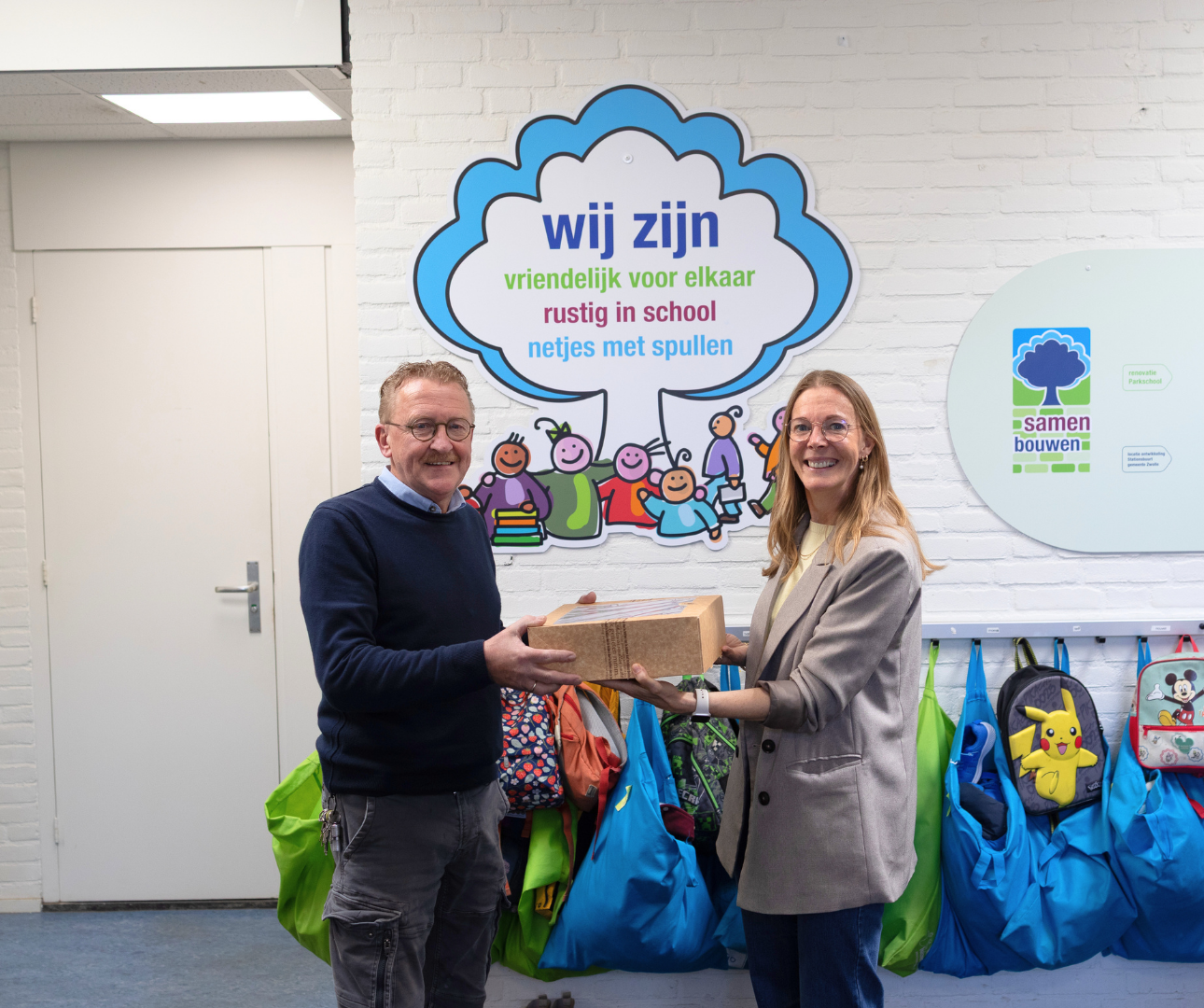 Collega overhandigt taart aan conciërge na aanleiding van een project.